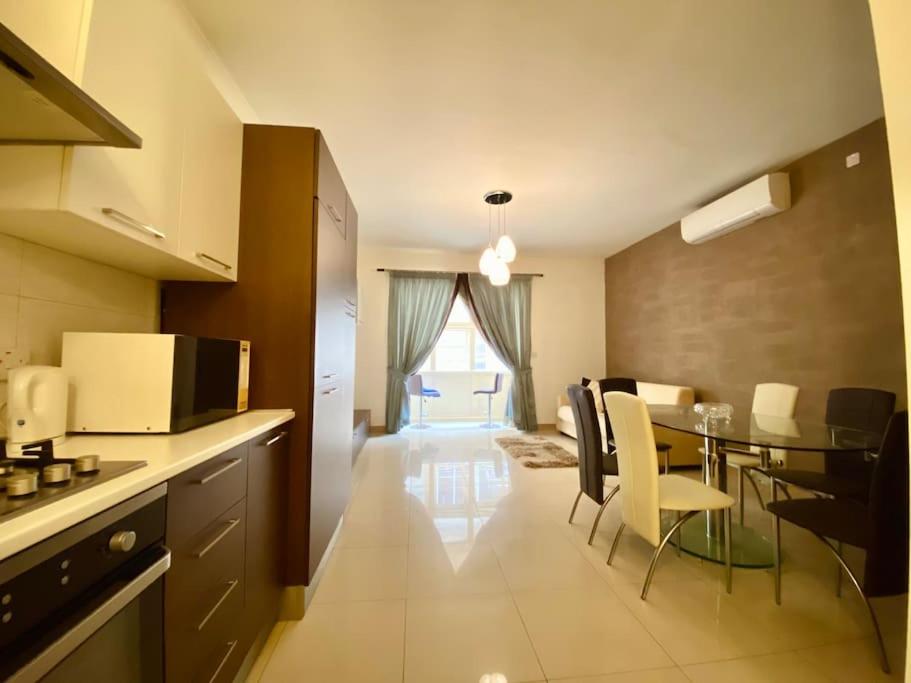 uma cozinha e sala de jantar com mesa e cadeiras em Good value for money - Close to D seafront & bars em Sliema