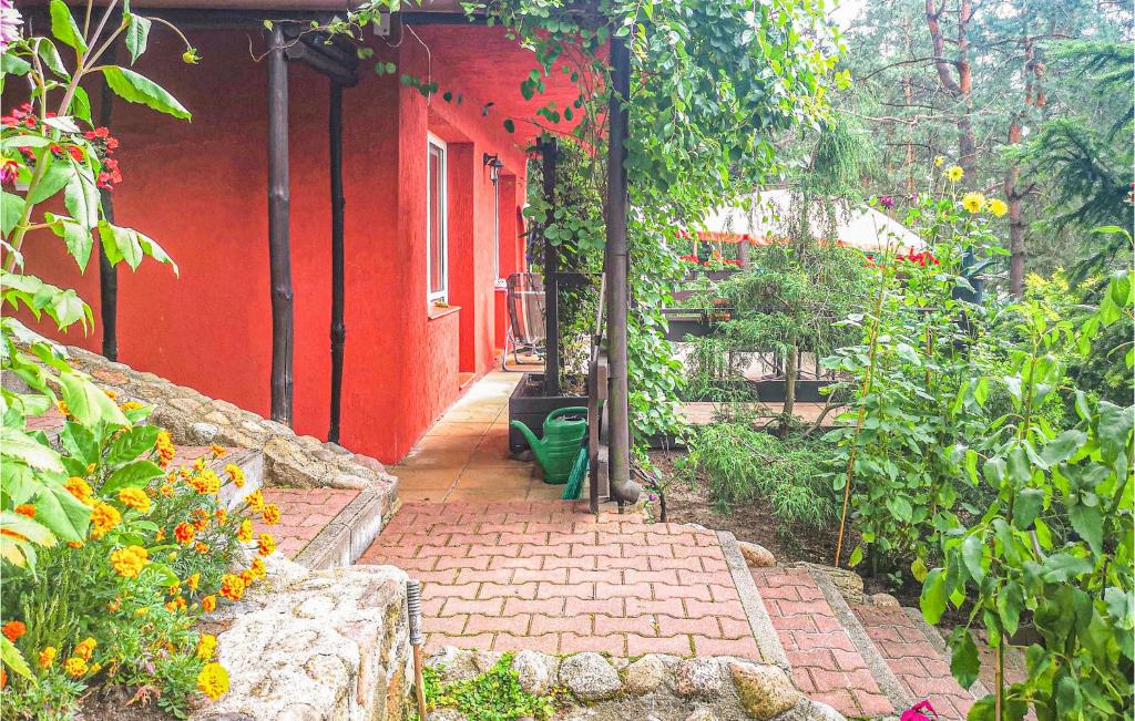 a red house with a pathway leading to a garden at Awesome Apartment In Stawiguda With Kitchen in Stawiguda