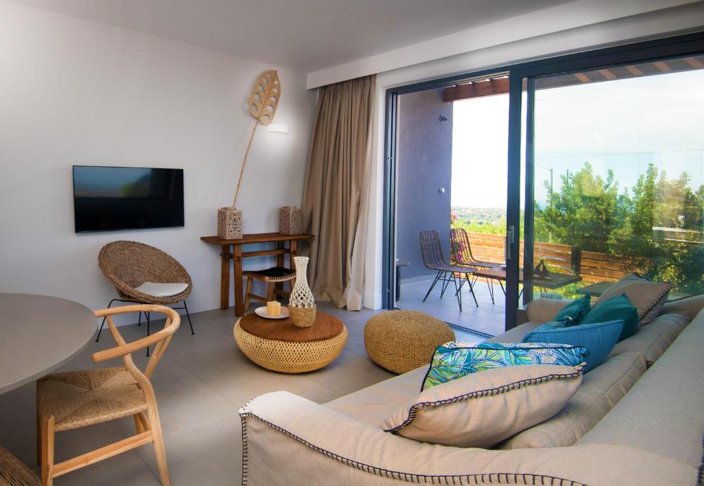 a living room with a couch and a large window at Dimeli - Sea View Villas in Foinikounta in Finikounta