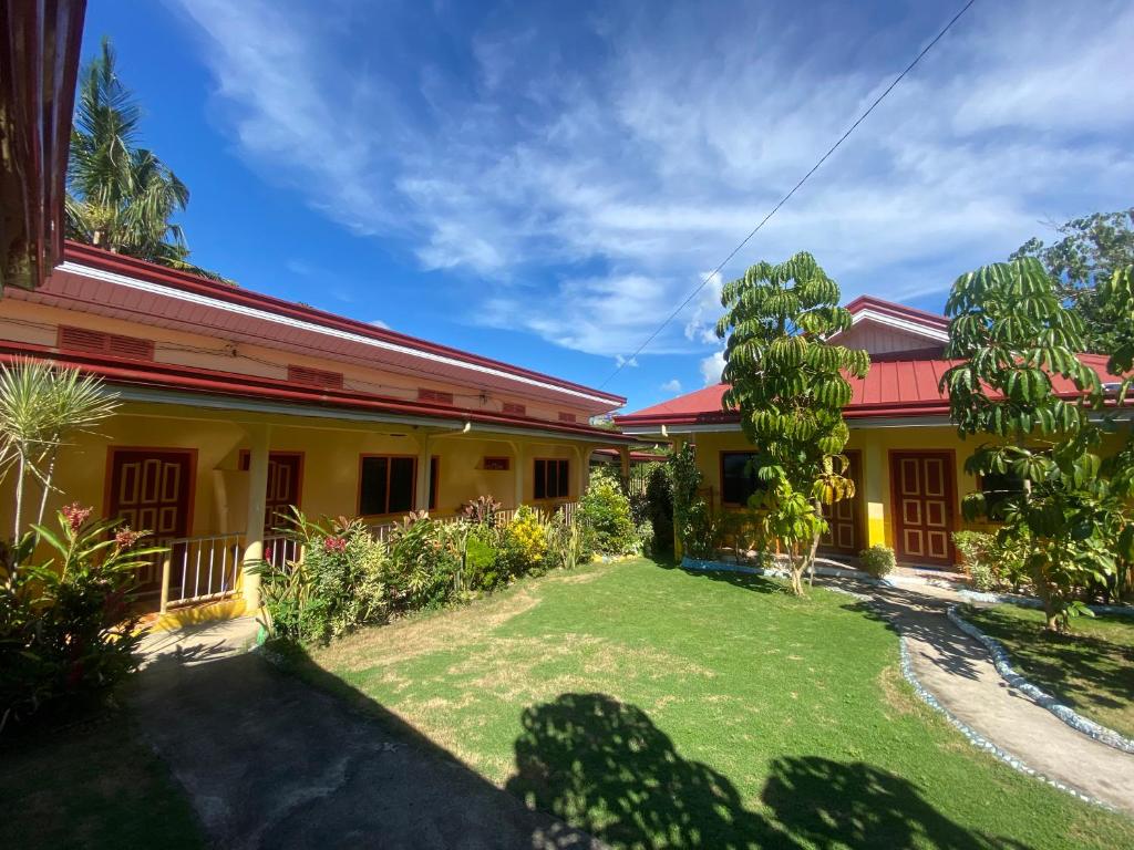 uma casa com um relvado em frente em Uptown Guesthouse em Siquijor