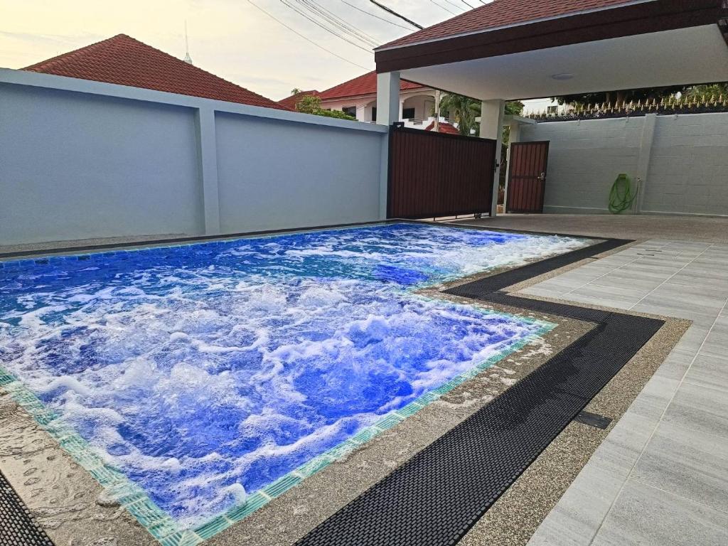 una piscina con agua azul y nubes pintadas en ella en Private Pool Villa with Jacuzzi at Royal Park Village - Walk to the Beach - MAX 3 ADULT MALES en Jomtien Beach