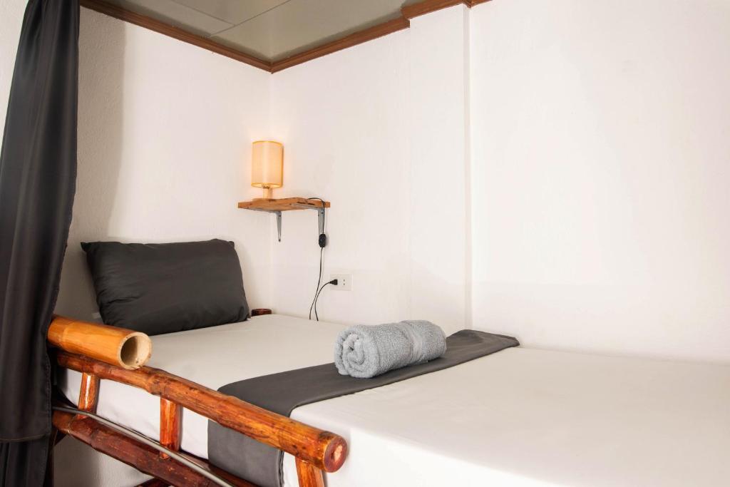 a small room with two beds and a lamp at Ohlala Hostel in Moalboal