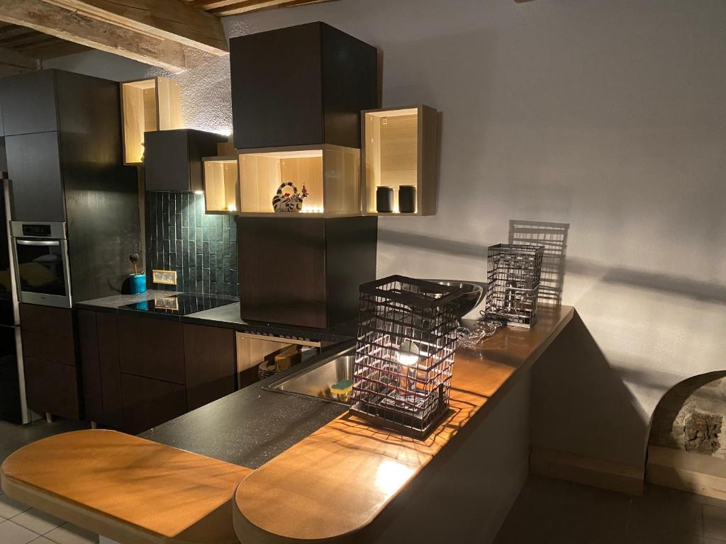 a kitchen with black cabinets and a wooden counter top at Maison Georges Couthon in Orcet