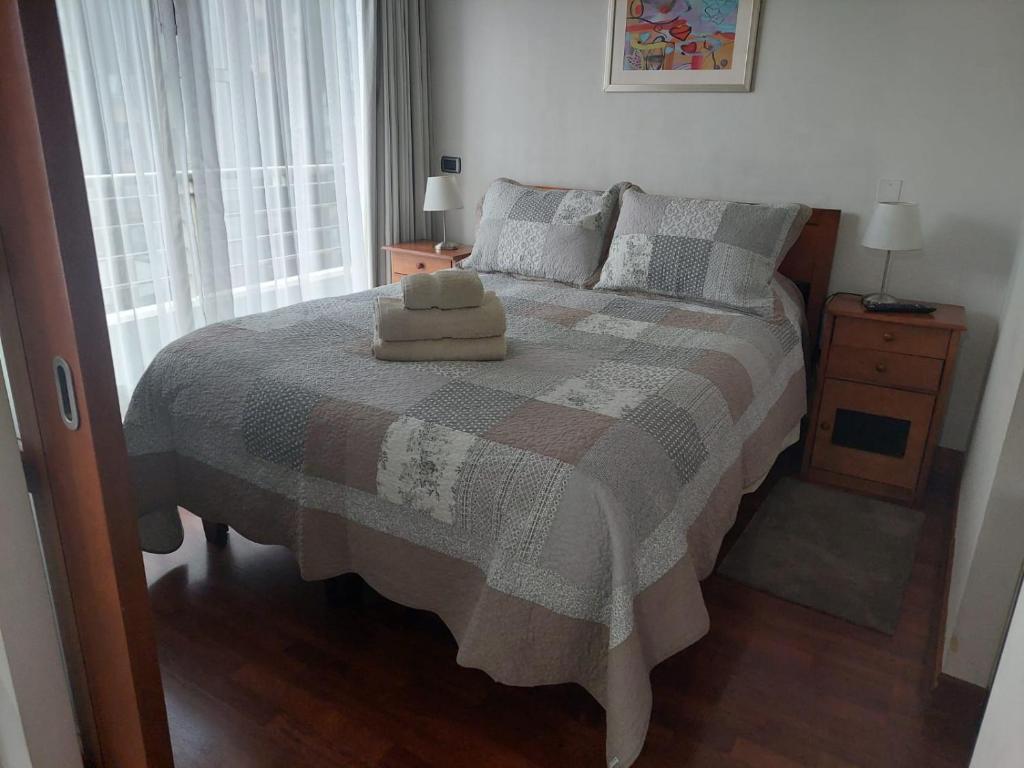 a bedroom with a bed with two towels on it at Austral Rentahome Santa Beatriz in Santiago
