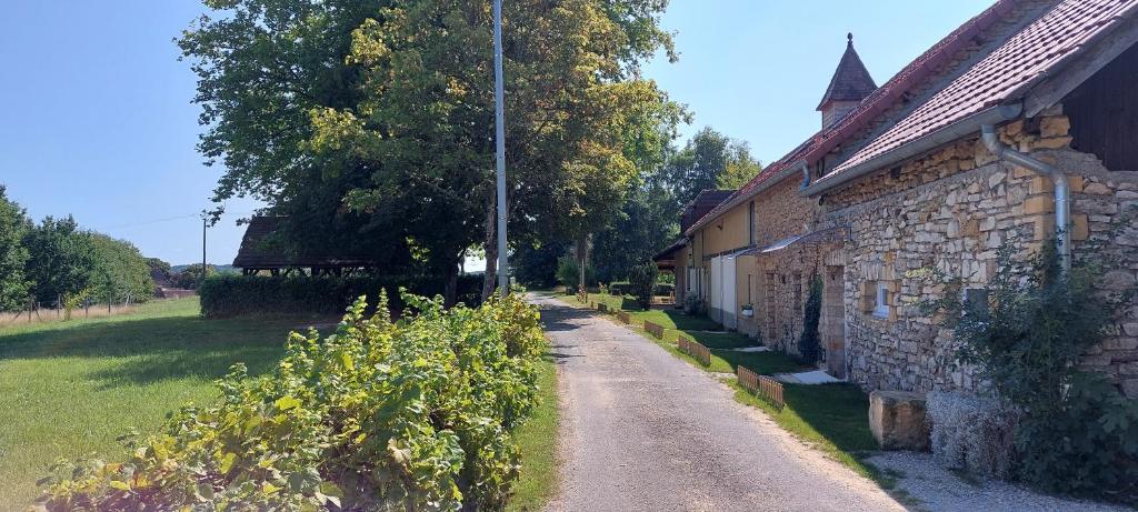 a dirt road next to a building next to a field at Combe Belle in Vézac