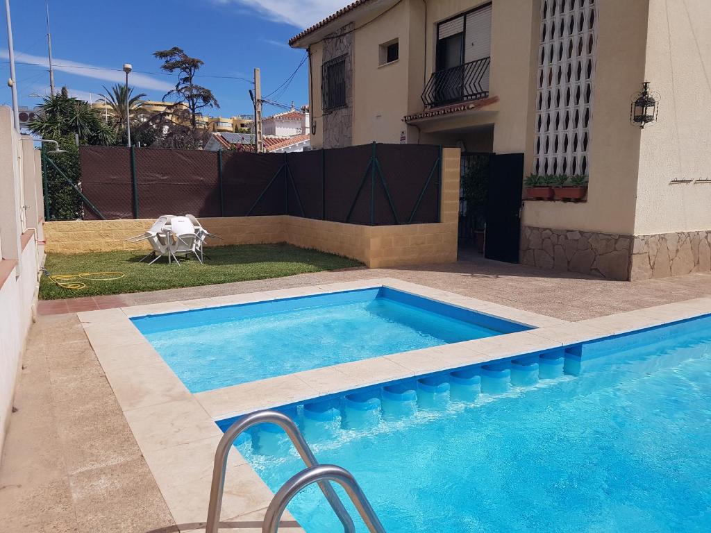 a swimming pool in front of a house at Chalet Puerto Marina Goya in Benalmádena