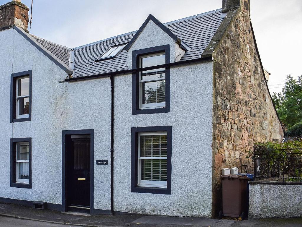 a white house with black windows and a door at Ivy Cottage in Falkland