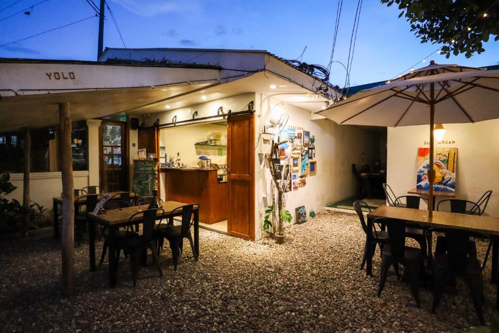 um restaurante com mesas e cadeiras e um guarda-sol em Ocean Breeze Hostel by Daily Sweet em Moalboal