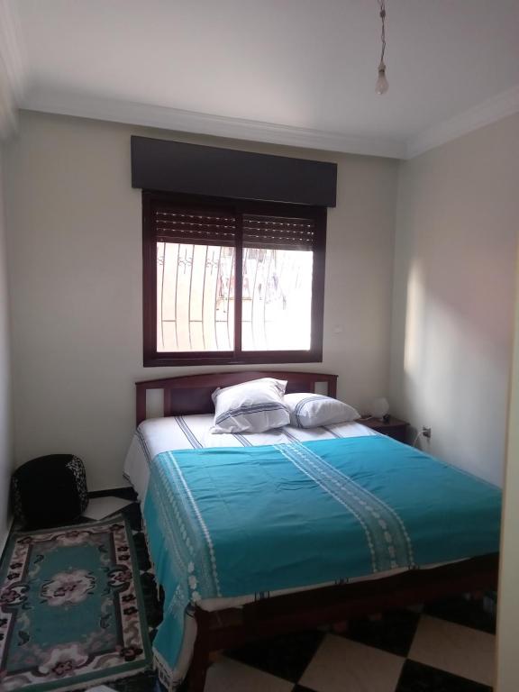 a bedroom with a large bed with a window at APPARTEMENT ZENITH in Casablanca