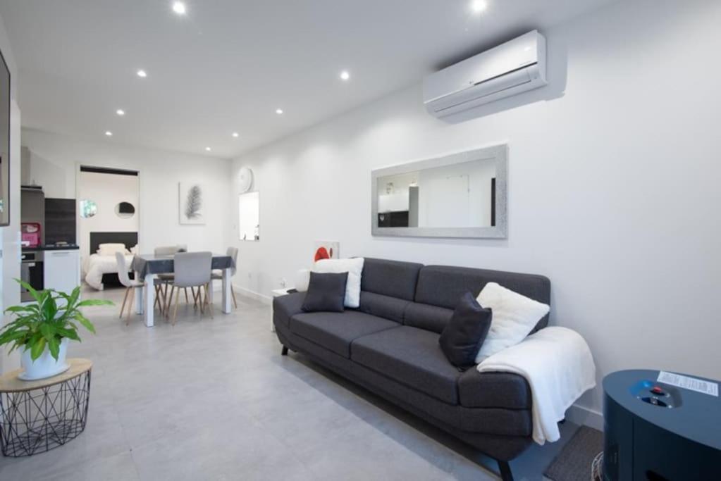 a living room with a couch and a dining room at Maison de ville à proximité du centre historique in Villeneuve-lès-Avignon