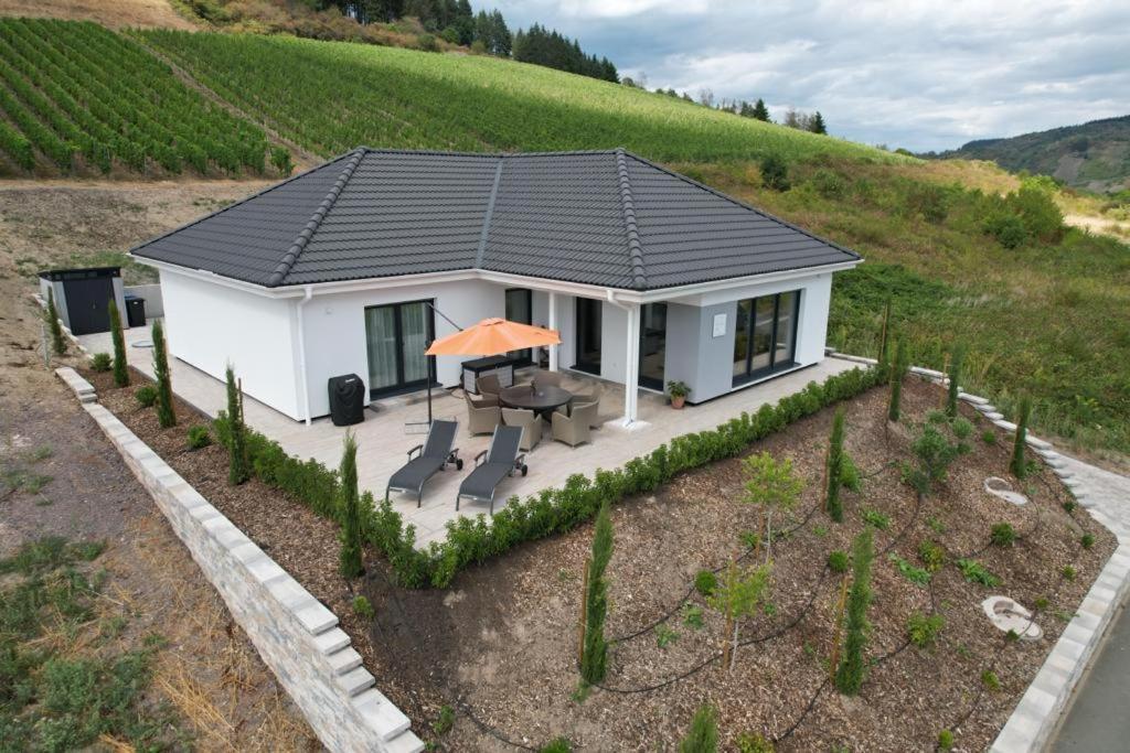 ein kleines weißes Haus mit einem Picknicktisch auf einem Feld in der Unterkunft NEU - Premium-Ferienhaus MOSEL-SONNE in Traben-Trarbach