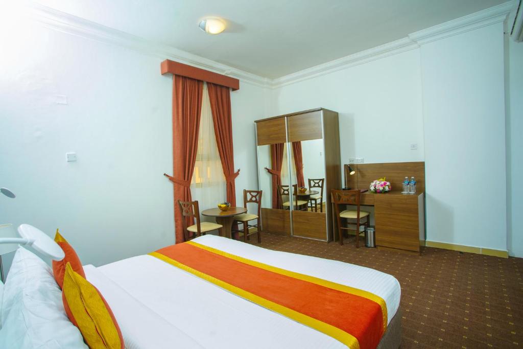 una camera d'albergo con letto, tavolo e sedie di La Villa Hotel a Doha
