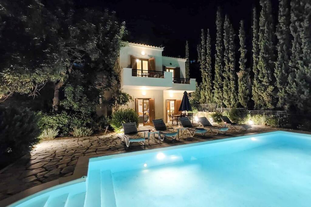 a villa with a swimming pool at night at Villa Nova s.r Sea View in Porto Heli