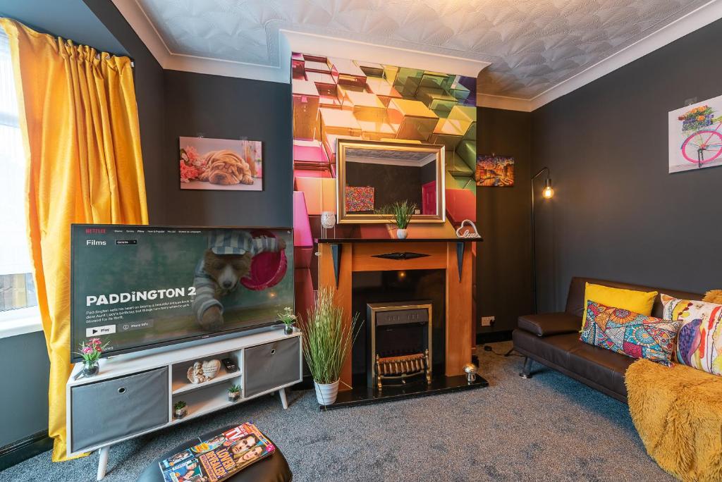 un salon avec une télévision et une cheminée dans l'établissement J's Home Away From Home FrEsH 2 Bedroom Garden Parking, à Hull