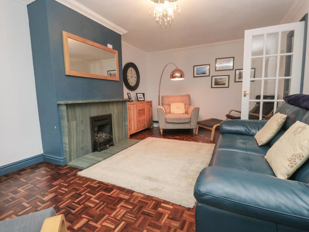 a living room with a couch and a fireplace at Ravenglass Retreat in Ravenglass