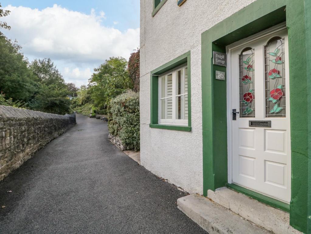 a white door with a green window and a street at Endgill Cottage in Ulverston