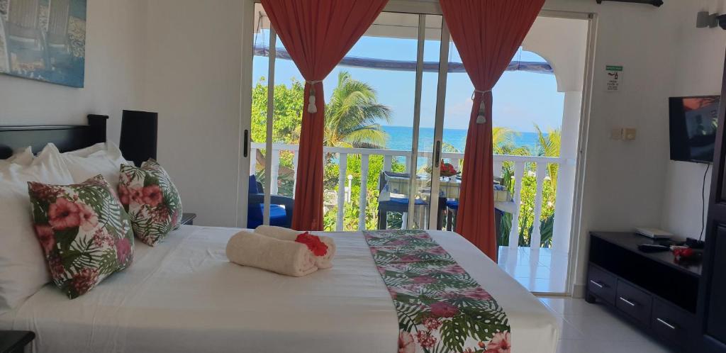 a bedroom with a bed with a view of the ocean at Sunset Cove Villa in Grand'Anse Praslin