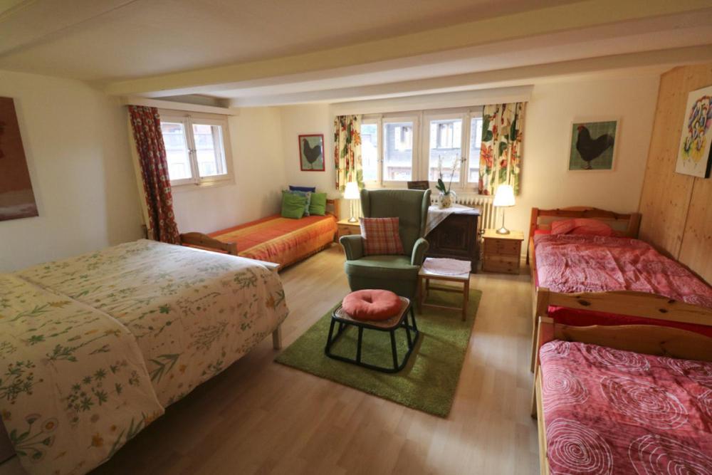 a bedroom with two beds and a living room at Chalet la Griotte in Villars-sur-Ollon