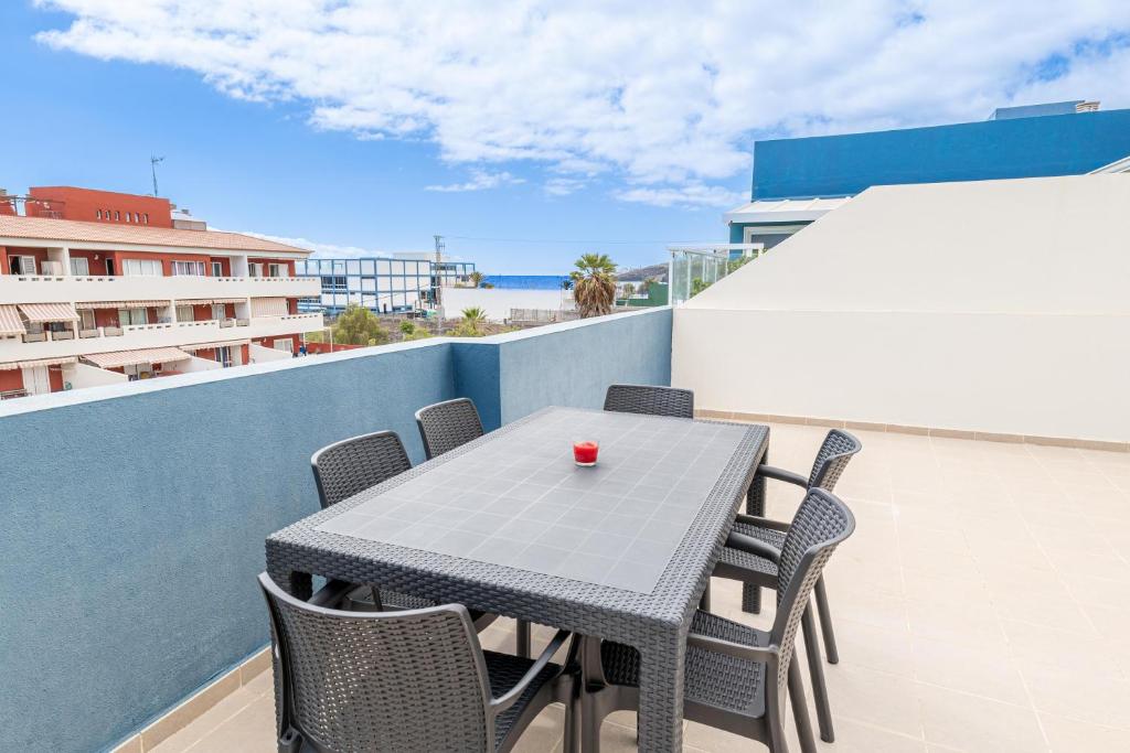stół i krzesła na balkonie z widokiem na ocean w obiekcie BLUE Home w mieście Puertito de Güímar