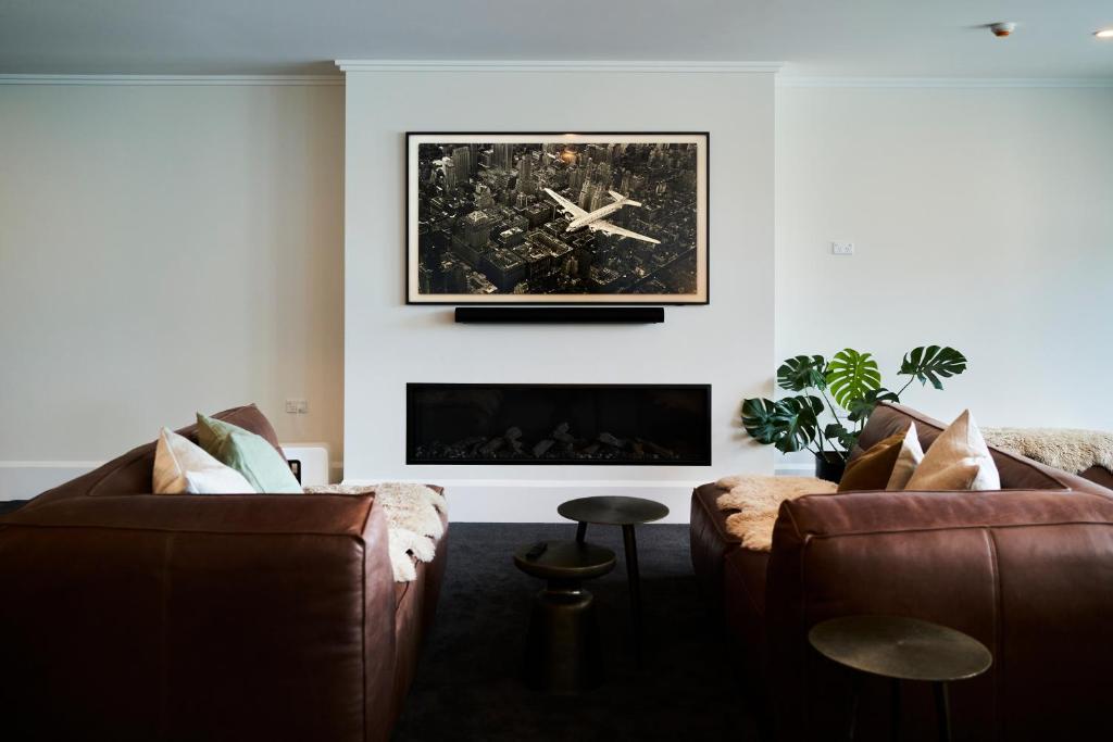 a living room with two couches and a fireplace at Laneway Apartments in Napier