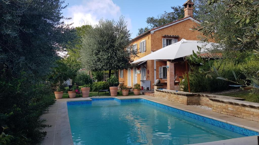 ein Pool vor einem Haus in der Unterkunft Home set in olive grove with stunning views in Mondavio