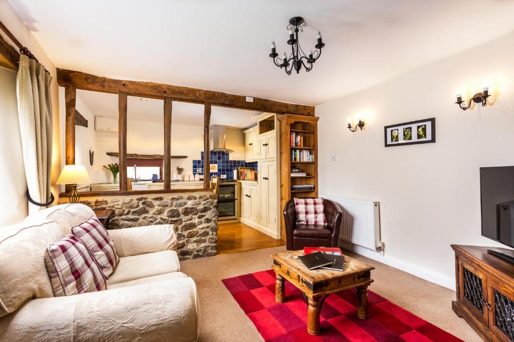a living room with a couch and a table at Holly Cottage in Honiton