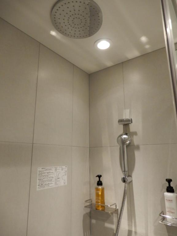 y baño con ducha y cabezal de ducha. en Smile Hotel Hiroshima, en Hiroshima