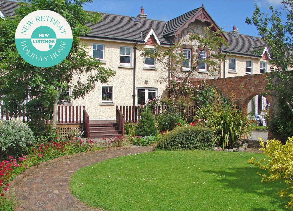 una casa con un cartel delante de un patio en Courtyard Holiday Cottage No 8, en Bettystown