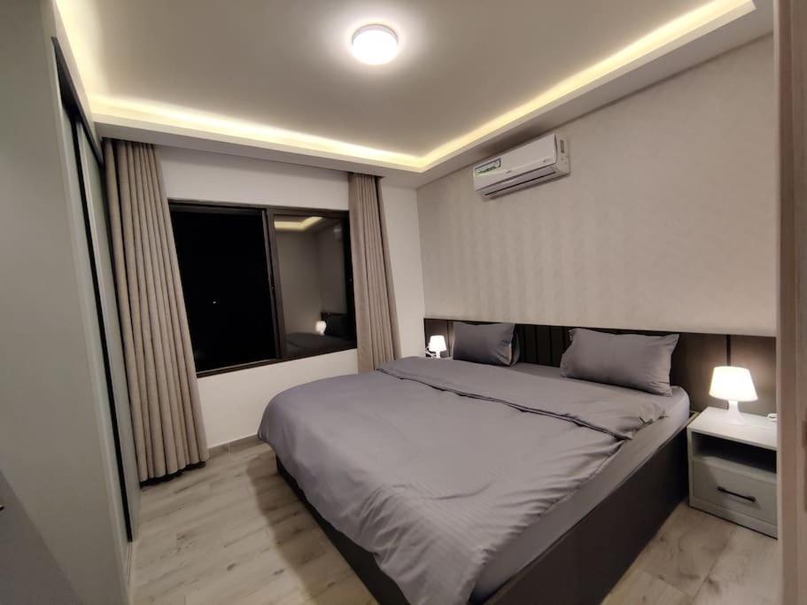 a small bedroom with a bed and a window at 43m luxury room near downtown and all services in Amman