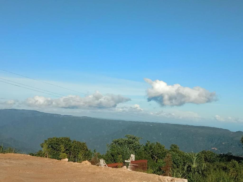 een uitzicht op een berg met een blauwe lucht en wolken bij Picture Perfect Homestay in Cherrapunji