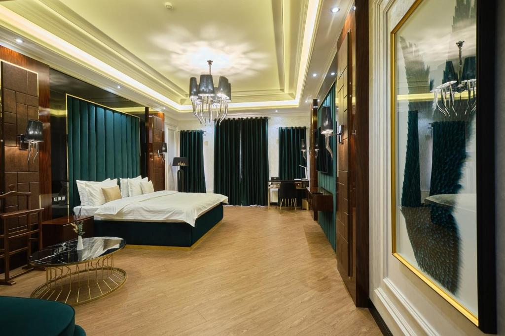 サマルカンドにあるEast Star Hotelのベッドとテーブルが備わるホテルルームです。