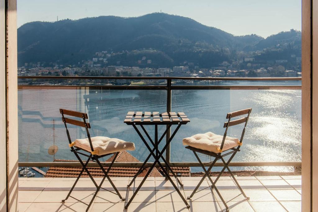 2 sedie e un tavolo sul balcone con vista di Window flat - The House Of Travelers a Como