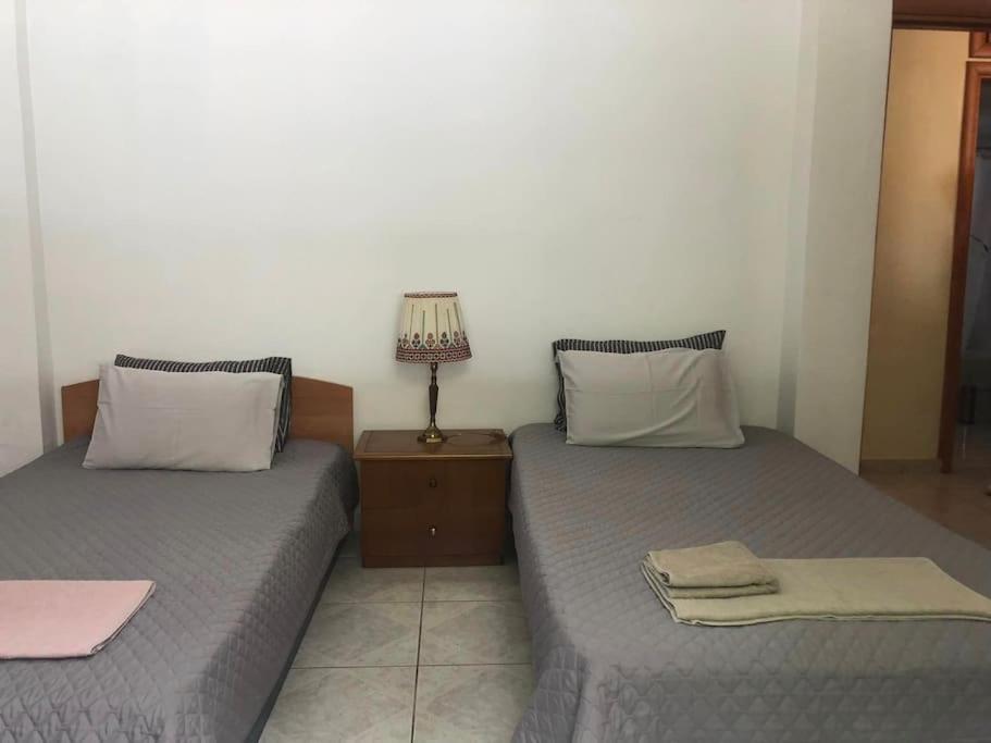two beds sitting next to each other in a room at Διαμερίσμα σε πολυκατοικία ως ολόκληρος χώρος. in Piraeus