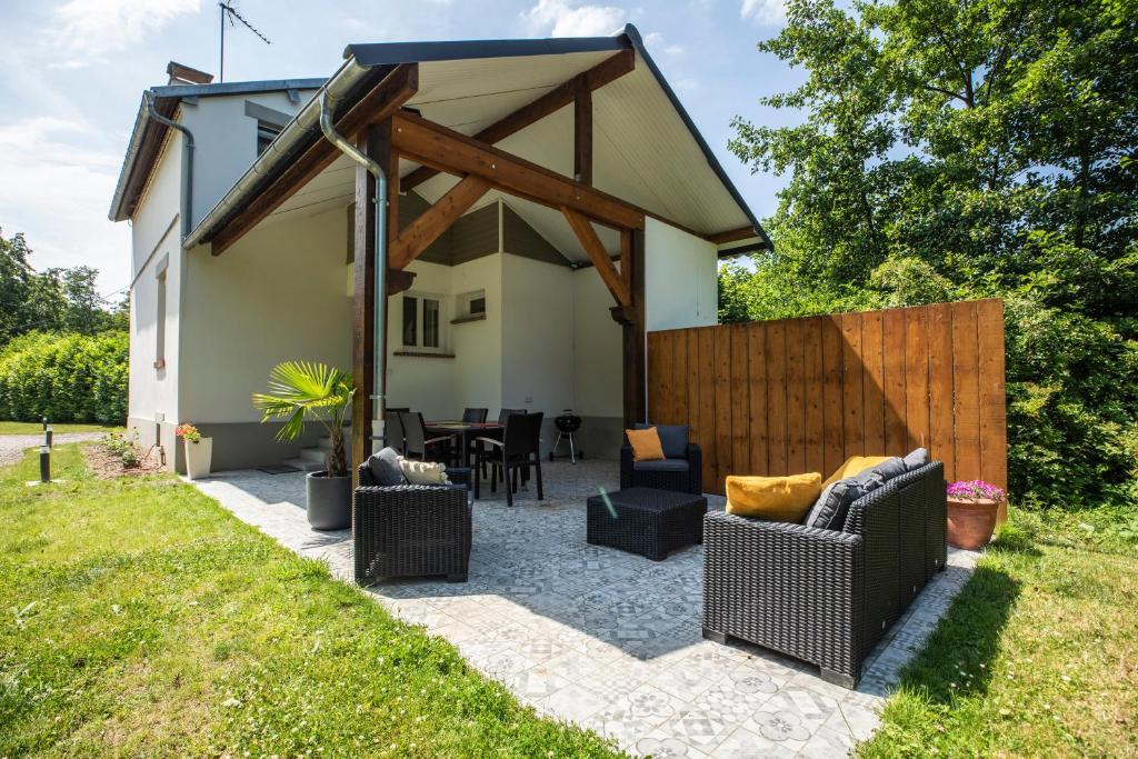 a backyard patio with furniture and a wooden fence at gite de l'ile ste hélène in Pitres