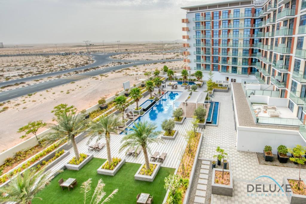 an aerial view of a resort with a pool and a beach at Posh Studio at Celestia A Dubai South by Deluxe Holiday Homes in Dubai