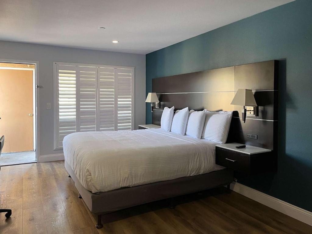 Un dormitorio con una cama grande con una pared azul. en Studio 6 Vallejo CA Napa Valley, en Vallejo