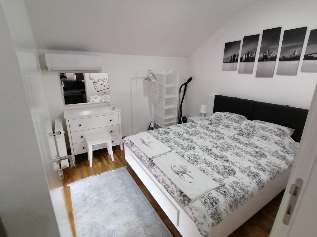 a small bedroom with a bed and a dresser at Nenadovic Apartman in Obrenovac