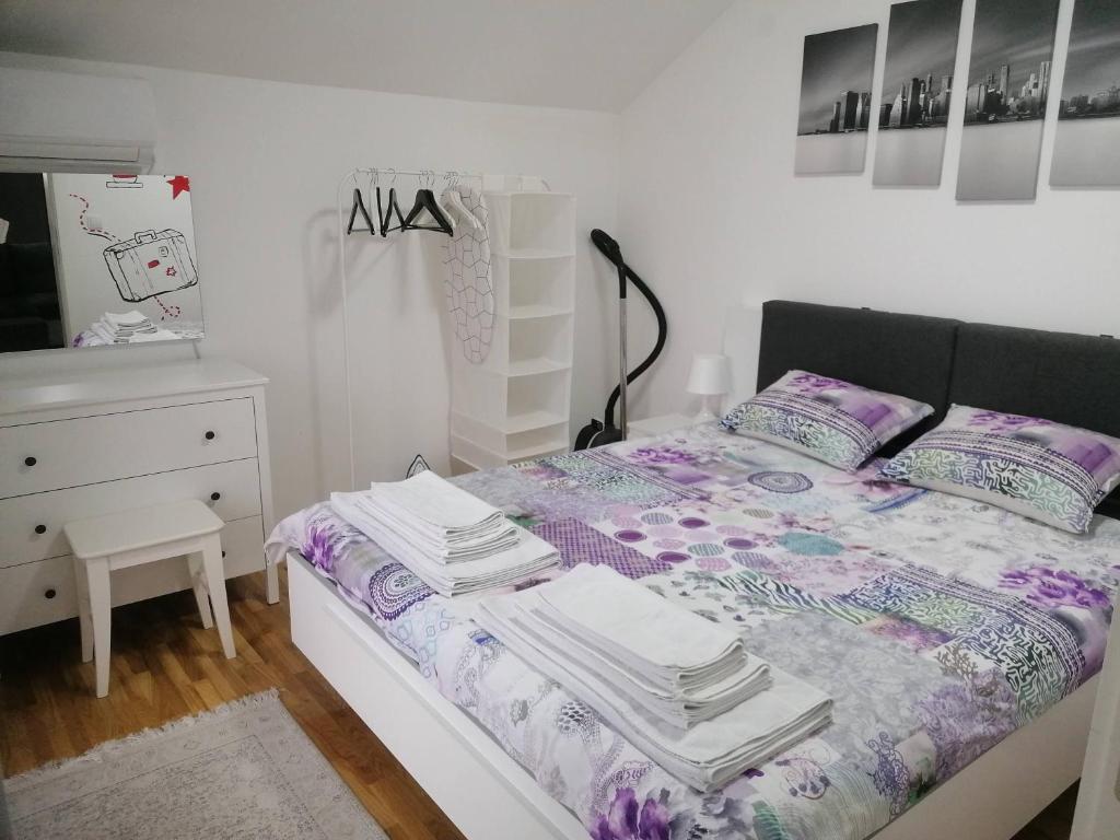 a bedroom with a bed and a dresser at Nenadovic Apartman in Obrenovac