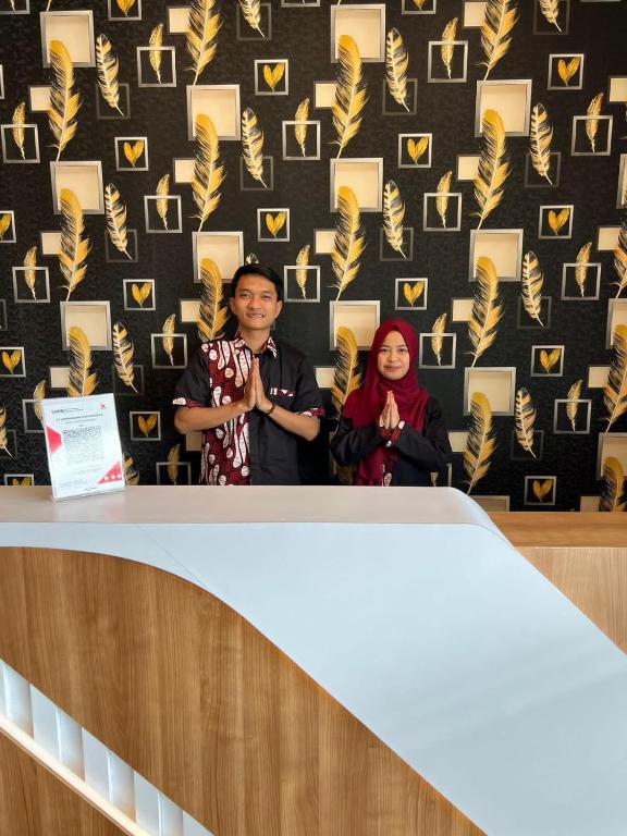 a man and a woman standing behind a podium at Dnaiko Syariah Hotel in Bukittinggi