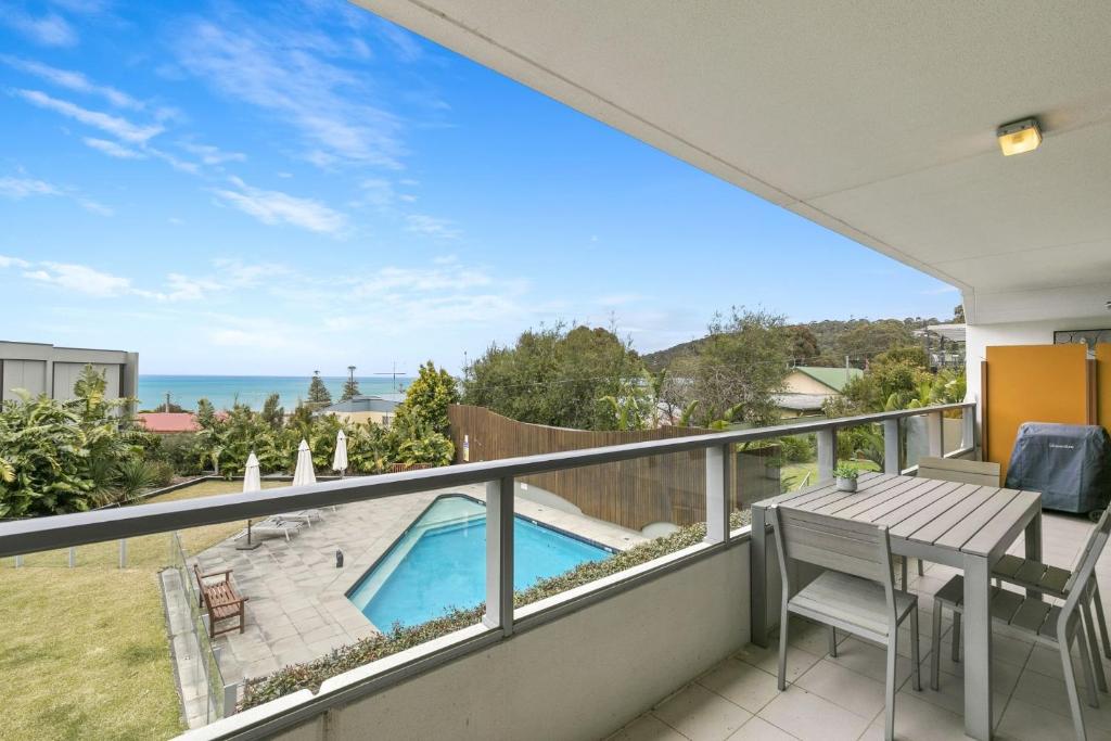 uma varanda com vista para uma piscina e para o oceano em Lorne Chalet Apartment 29 em Lorne