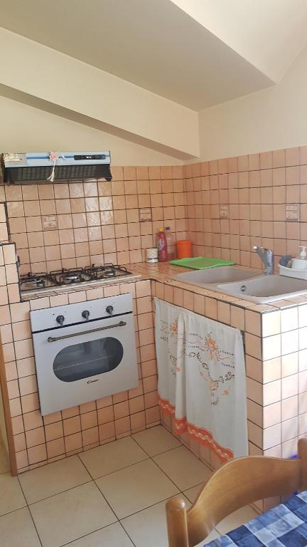 a kitchen with a stove and a sink at Appartamento e Attico Epi in Lucca Sicula