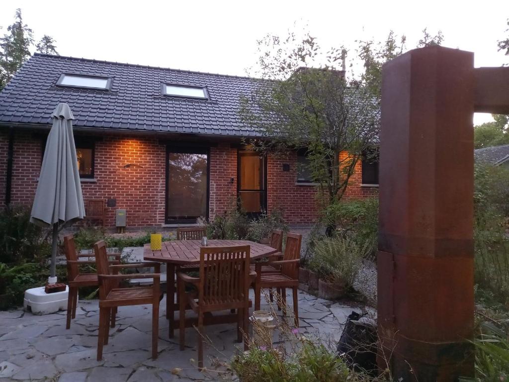 een patio met een tafel en stoelen en een parasol bij Chateau Brulant in Somme-Leuze