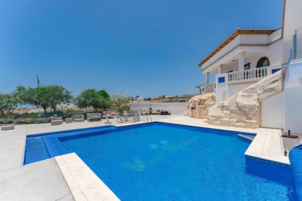 una piscina frente a una casa en LUXURY VILLA NAUTILUS Heated pool Spa en Adeje