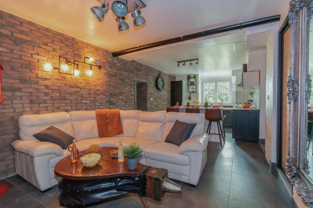 ein Wohnzimmer mit einem weißen Sofa und einem Tisch in der Unterkunft Private & Comfortable Apartments in Puttelange-aux-Lacs