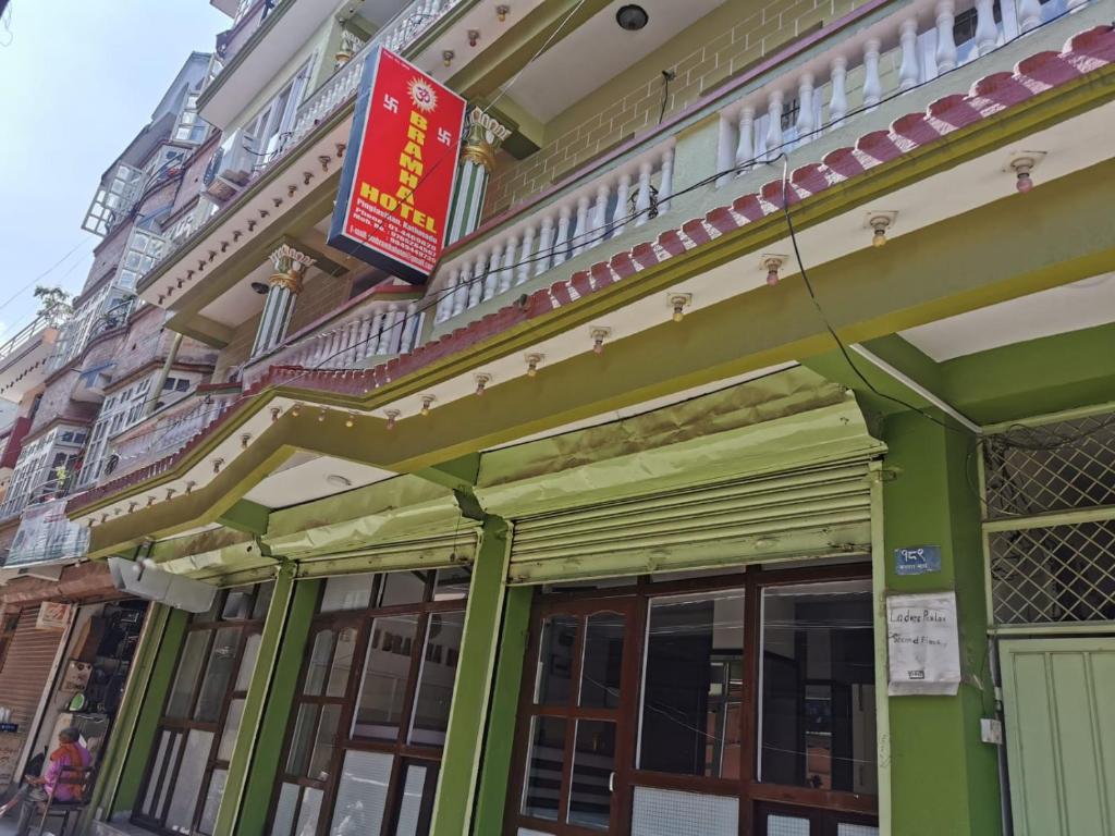 un edificio verde con un cartel. en Om Bramha Hotel, en Katmandú