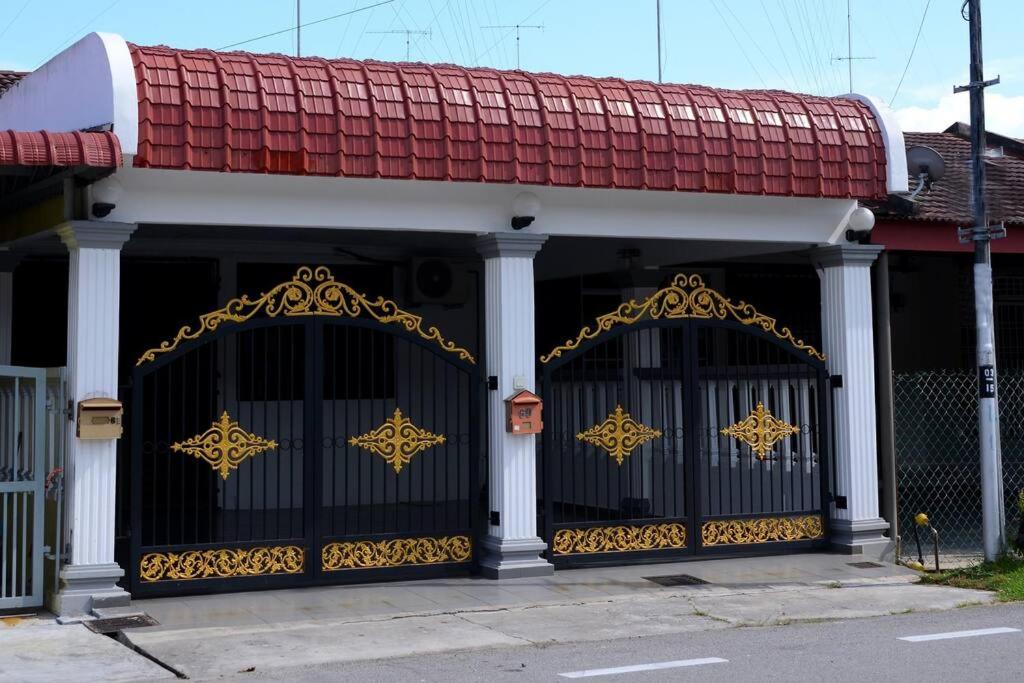 a building with a black gate with gold decorations at Wonderful Homestay at Muar in Muar