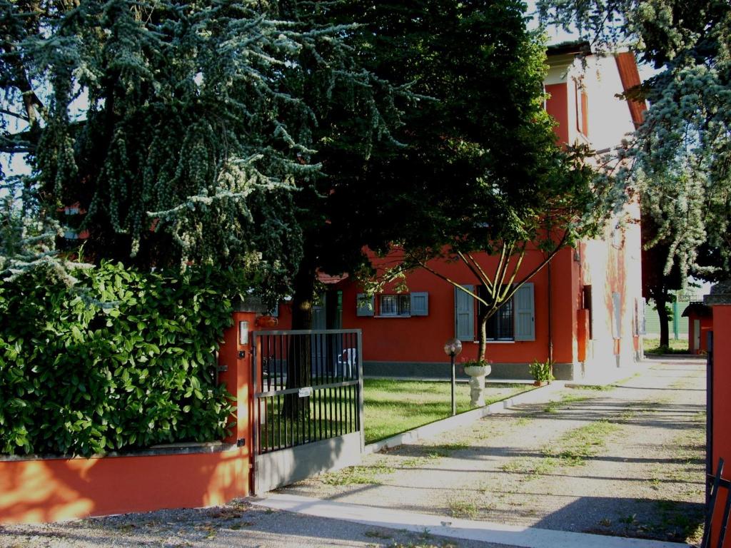 a red house with a gate in front of a street at Royal Room & Breakfast in Modena