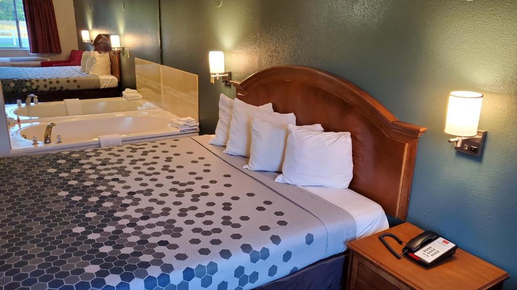 a hotel room with a bed and a bath tub at Stonewood Inn & Suites of Carrollton - Smithfield in Carrollton