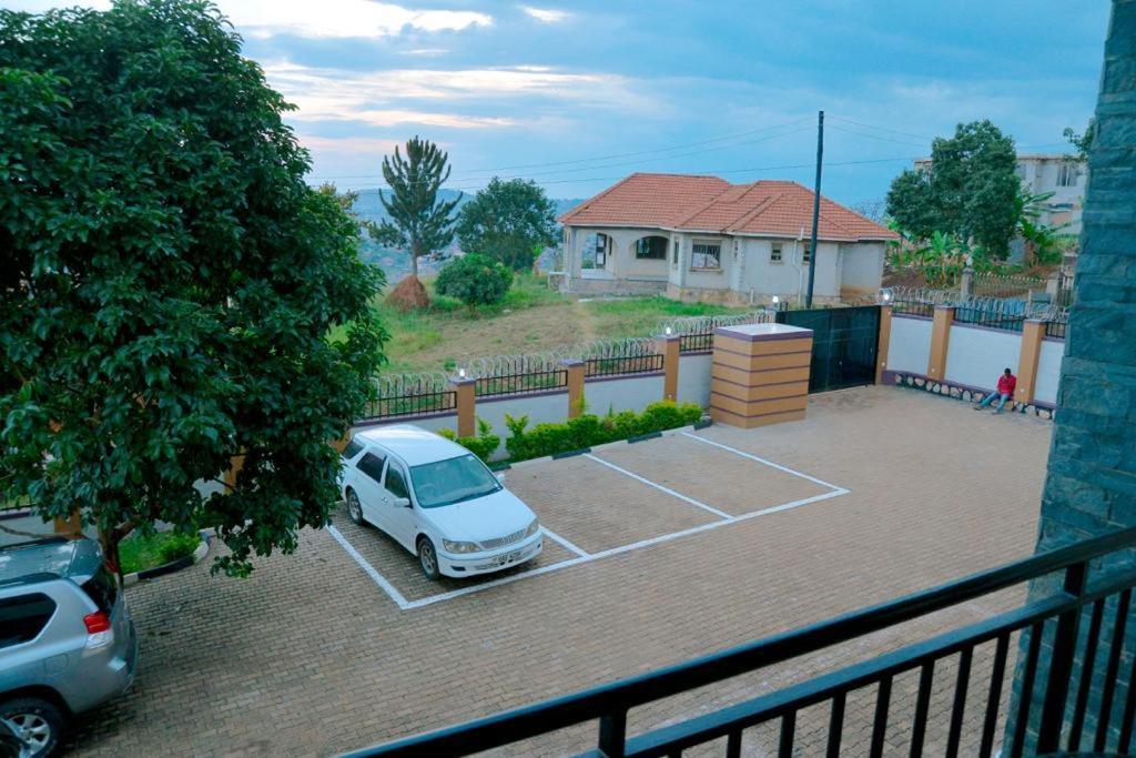 a car parked in a parking lot in front of a house at Broadbills Haven apartment in Kampala