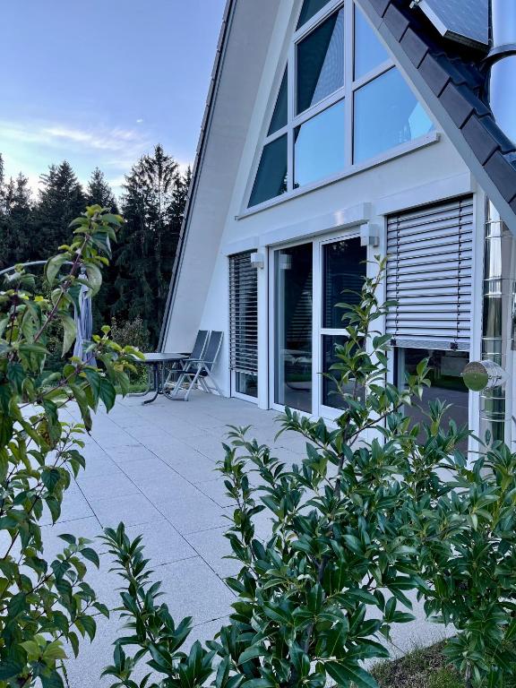 uma casa com um pátio com uma cadeira em Ruheoase mitten in der Natur em Wilhelmsdorf